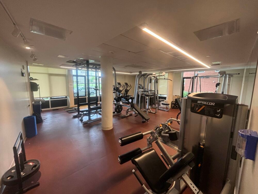 a picture of a small gym with burgundy floors and various machines