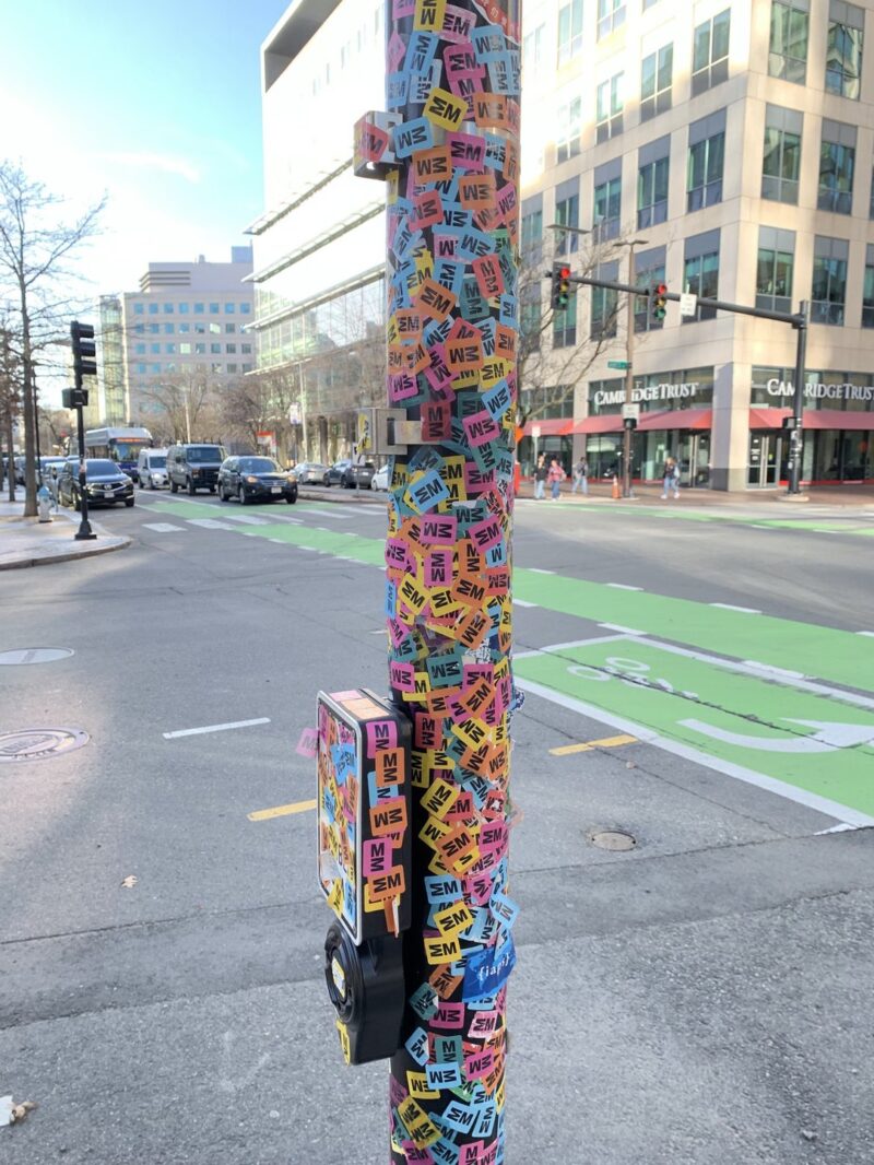a street pol covered in multicolored stickers