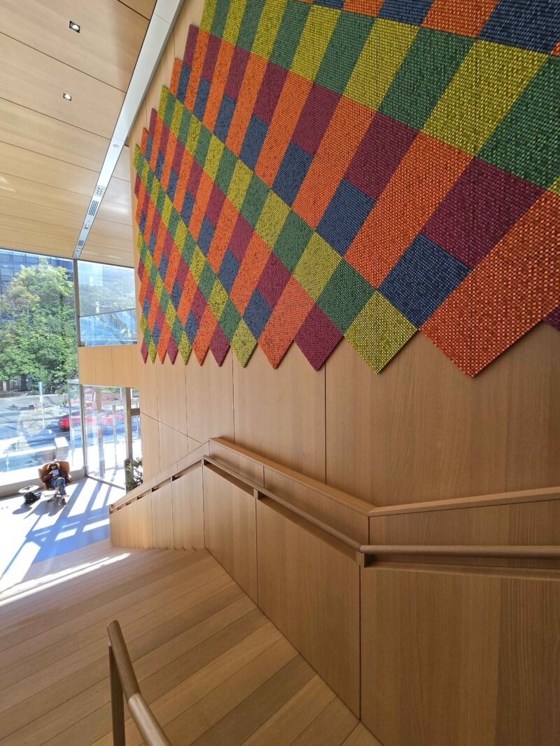 a wooden staircase has multicolored tiles along the wall