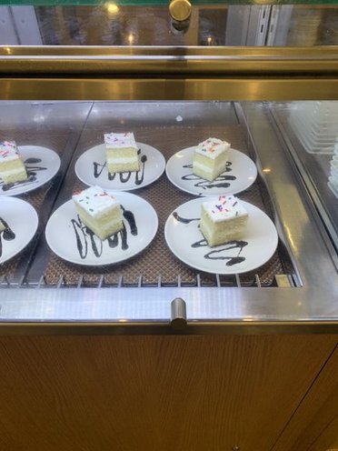 a bunch of plates of cakes, with decorate chocolate zigzags beneath them
