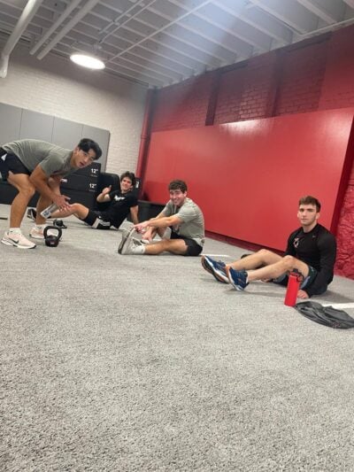 Men's soccer team stretching on turf.