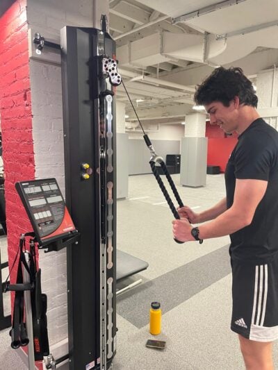 Soccer player doing an exercise on the cable machines.