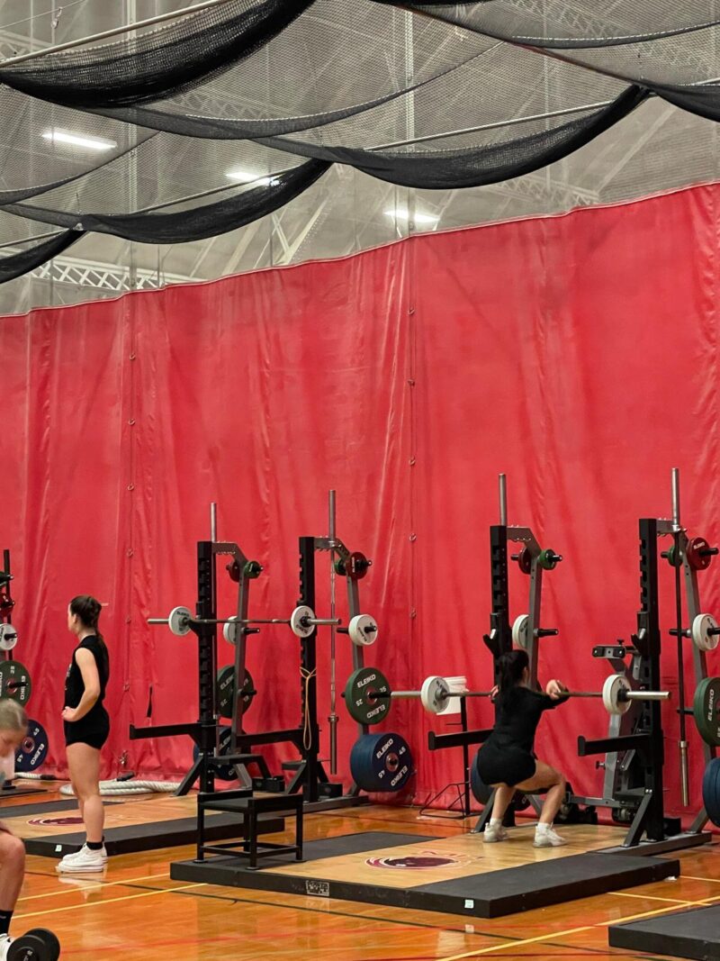 Team lifting at a weight rack.
