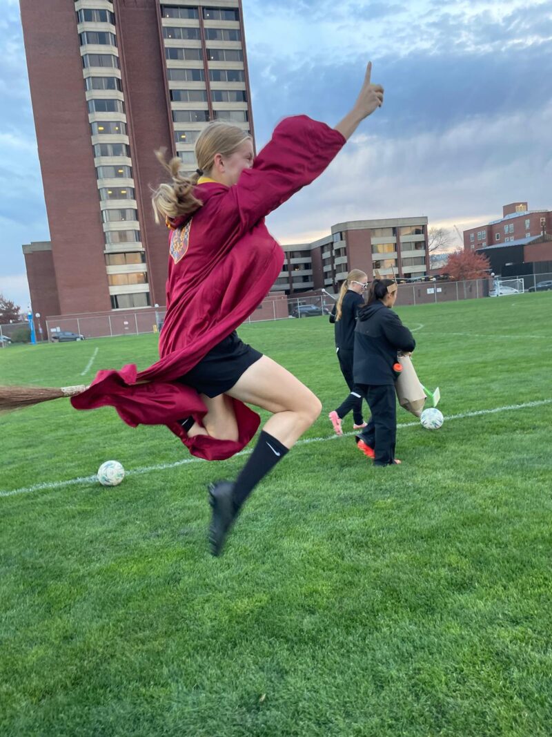 Girl dressed up as Harry Potter on a broom.