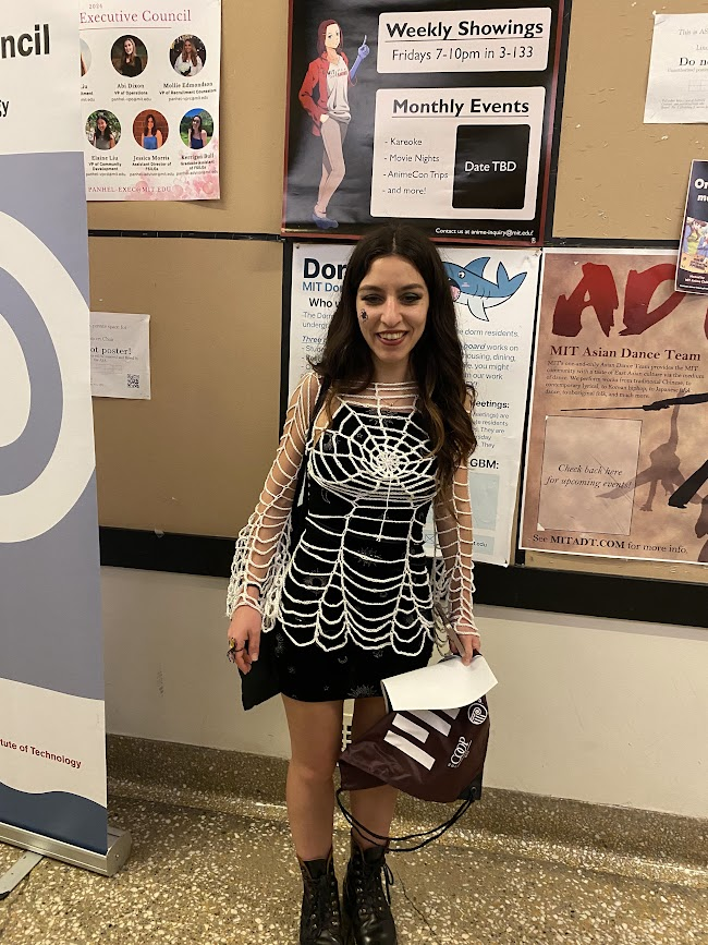 person standing in a dress and a knitted web covering costume