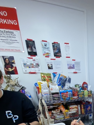 posters on a wall above a shelf filled with food