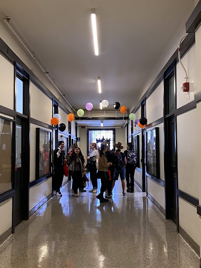 halloween themed balloon arch hanging over the entry to a long corridor called the infinite