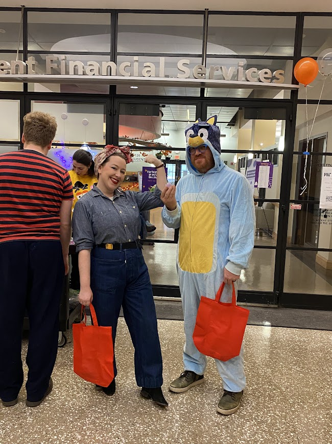 a photo of two people in halloween costumes! one of them is i think dressed up as Bluey? the other is rosie the riveter i think