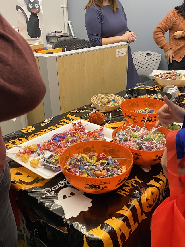table with candy on top and there is a poster of Kiki the cat from Kiki's Delivery Service in the background