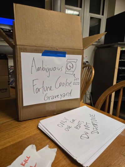 a box with a sign that says "ambiguous fortune cookie graveyard"