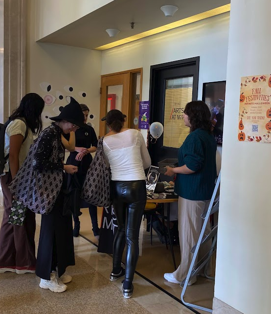 people dressed up in costumes crowding around the Arts at MIT stall