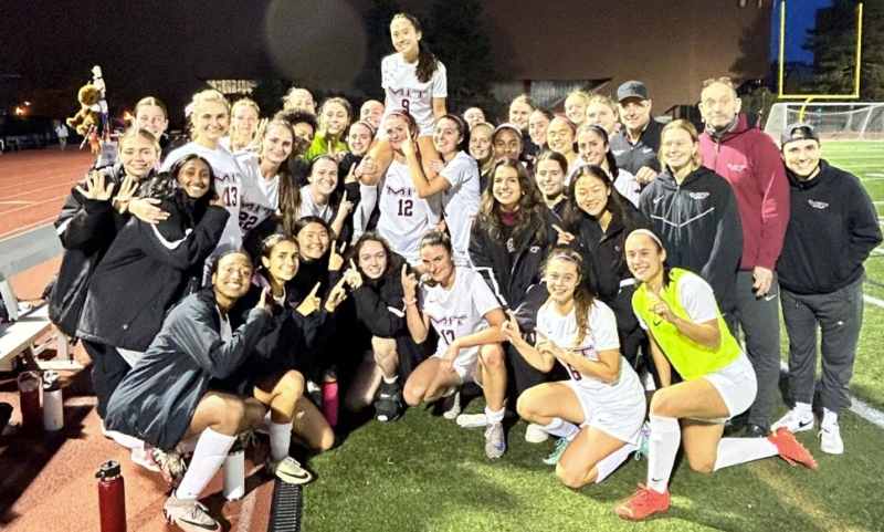 Soccer team hugging and smiling.