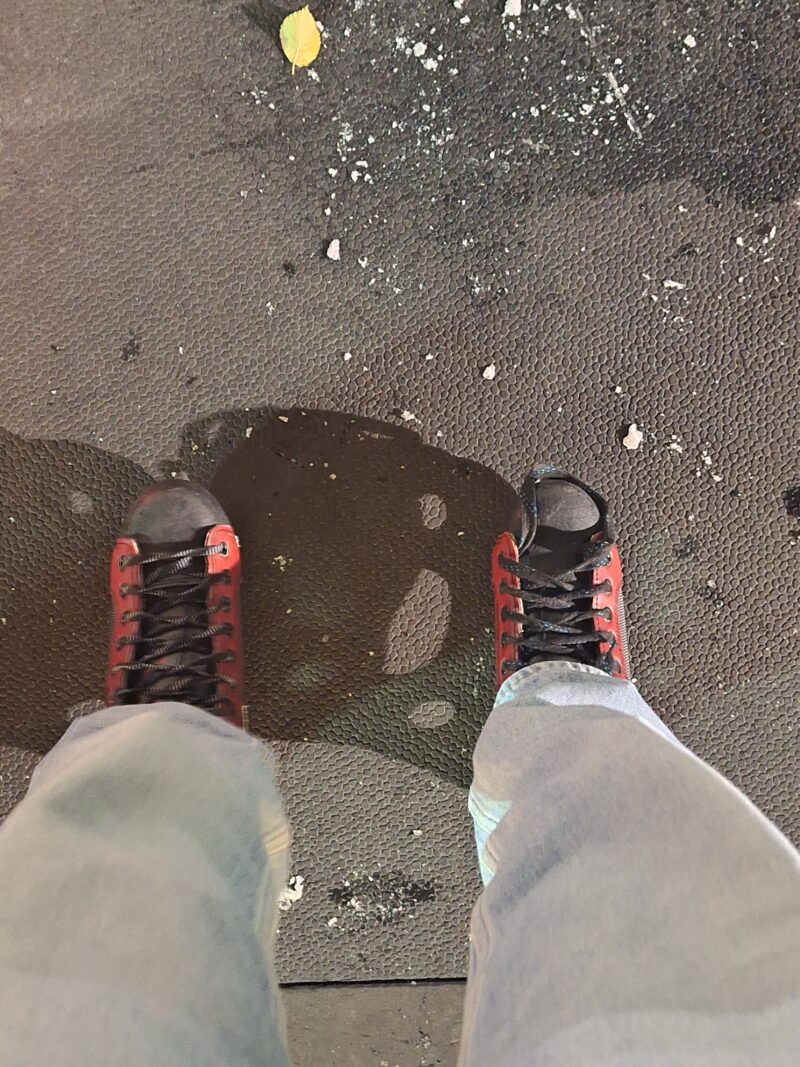 A photo of two ice skates on the ground outside of the ice rink.