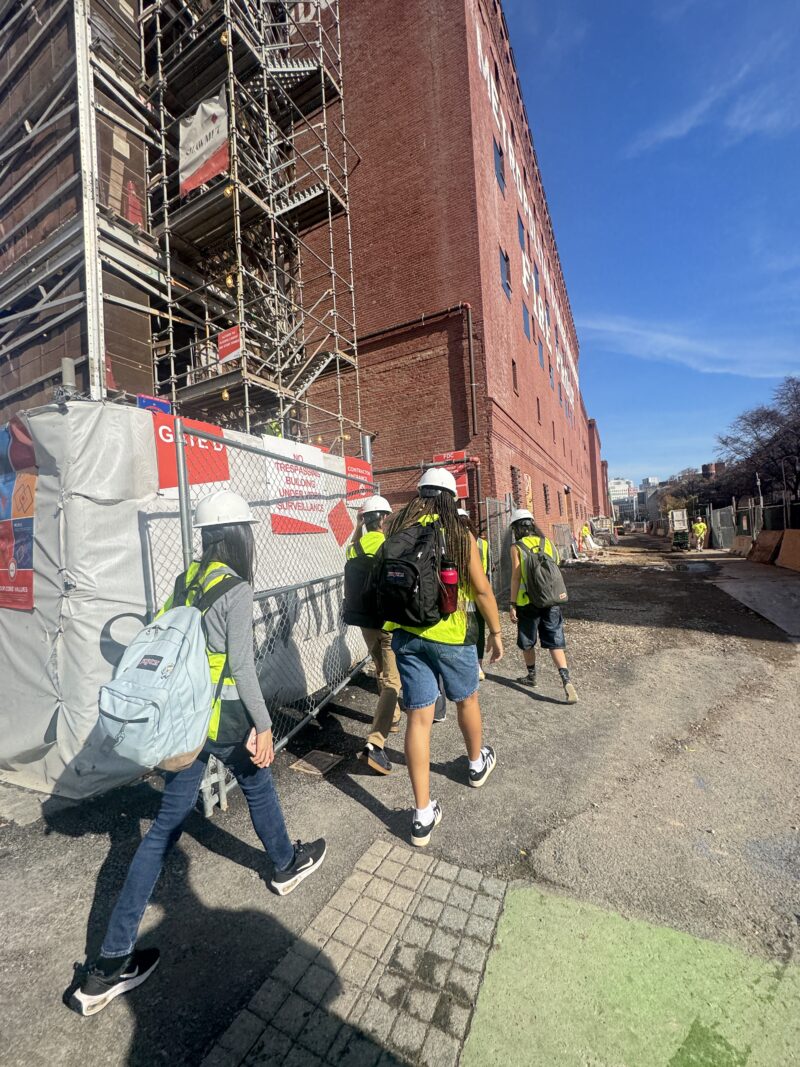 Photo of students walking towards Metropolitan Warehouse Building