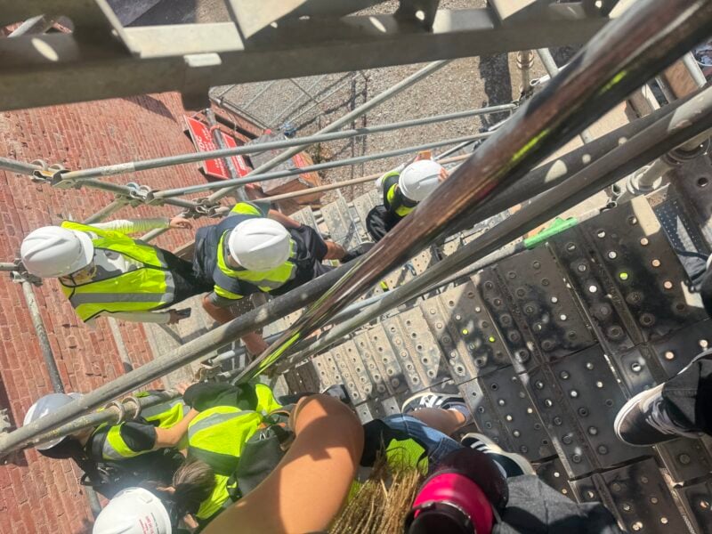Photo of students walking up construction stairs on the side of the Metropolitan warehouse building.