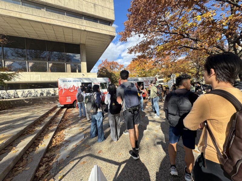 Outdoor photo of students lined up in front of the student center waiting to get ice cream from an ice cream truck.