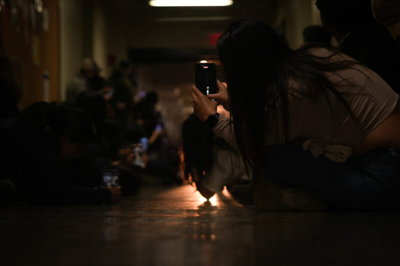 Photo of people leaning in to take photos of the sun