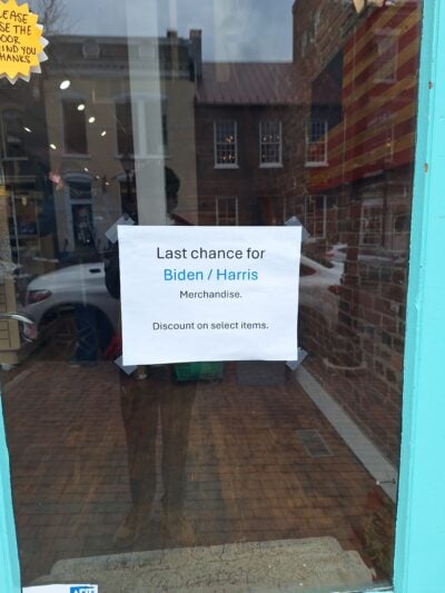 A photo of a glass door to a store front signaling that it is the last sale of 2024 Biden/Harris merchandise. 