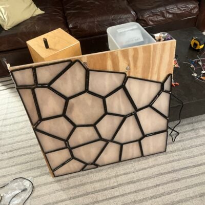 A work-in-progress picture of the plywood board with acrylic Voronoi tiles, with initial electrical wiring