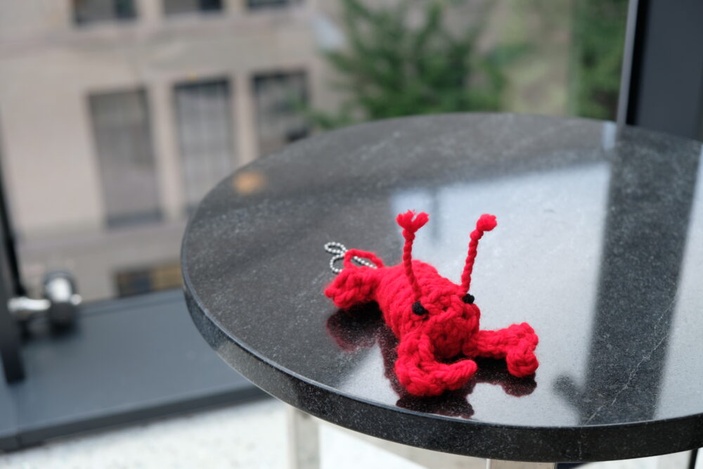 a crocheted lobster on a shiny stone table