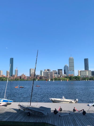 long boardwalk near a river with a skyline of tall buildings on the other side