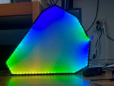 A triangular acrylic panel glowing blue, yellow and green