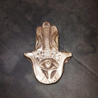 A bronze hamsa with the eye in the middle of an inscribed Tree of Life