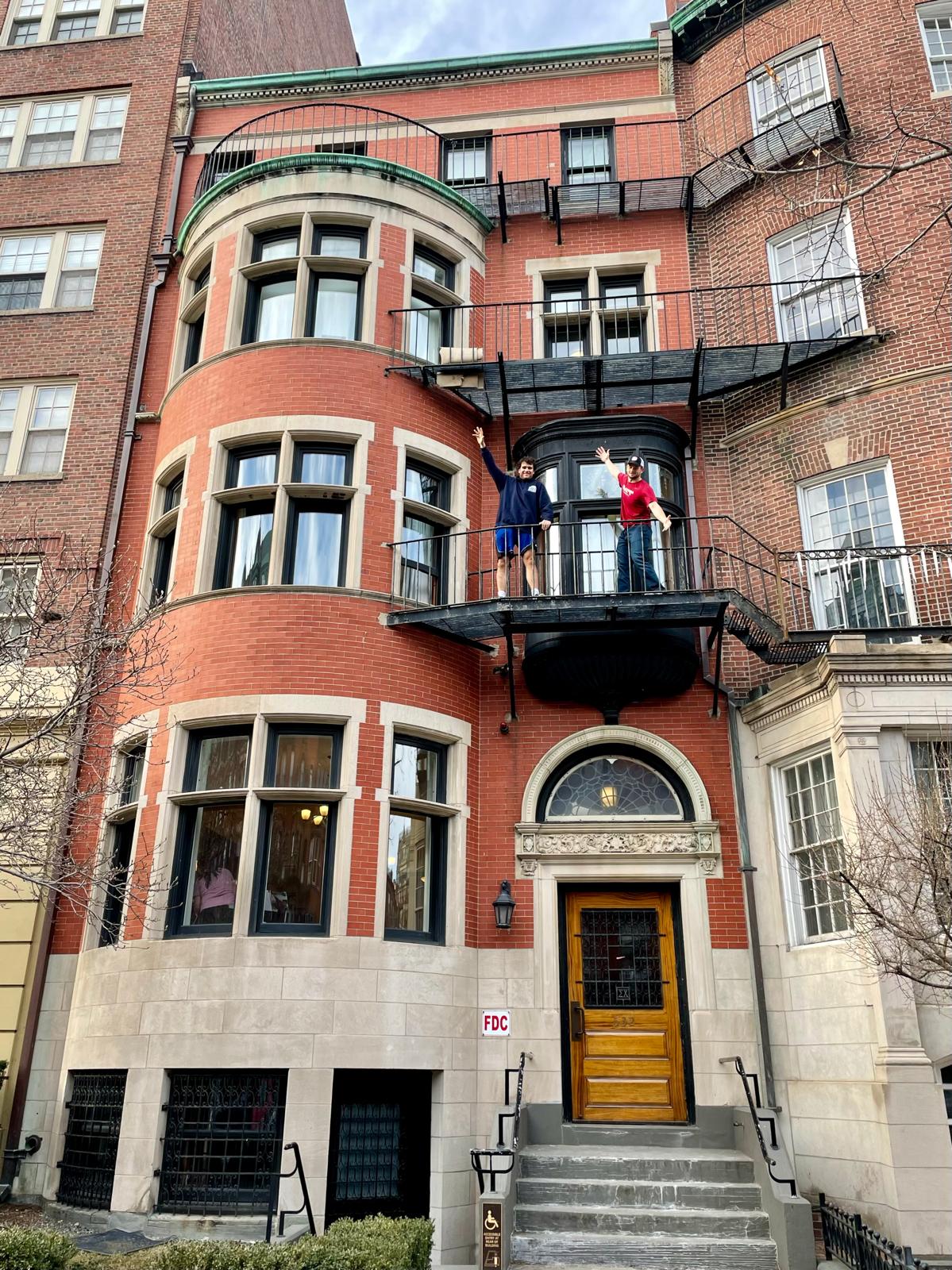 Tall brick building nestled right next to two other buildings.