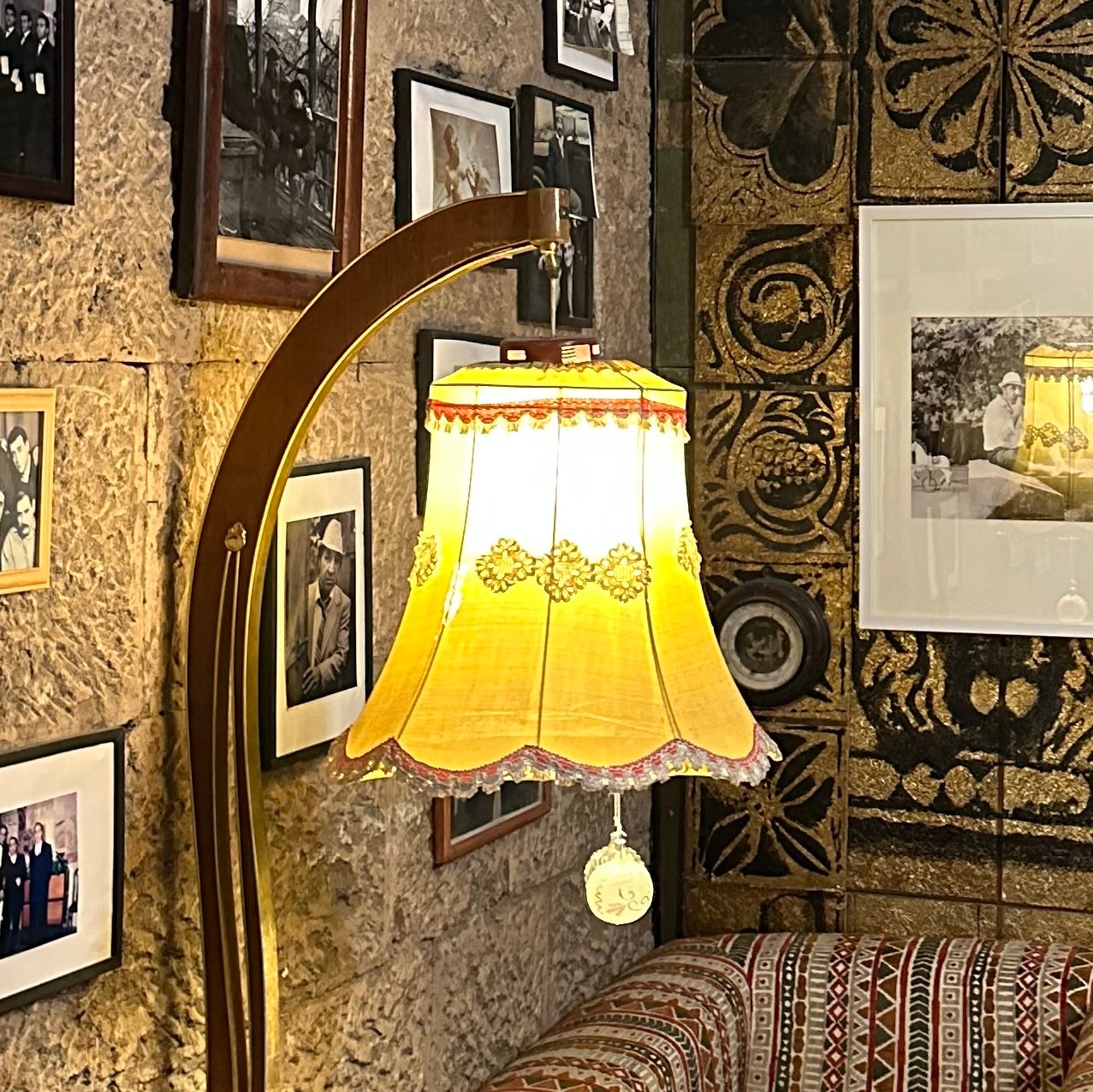 Cozy Vintage-Themed Lounge – A warmly lit corner of a lounge features patterned armchairs, framed…