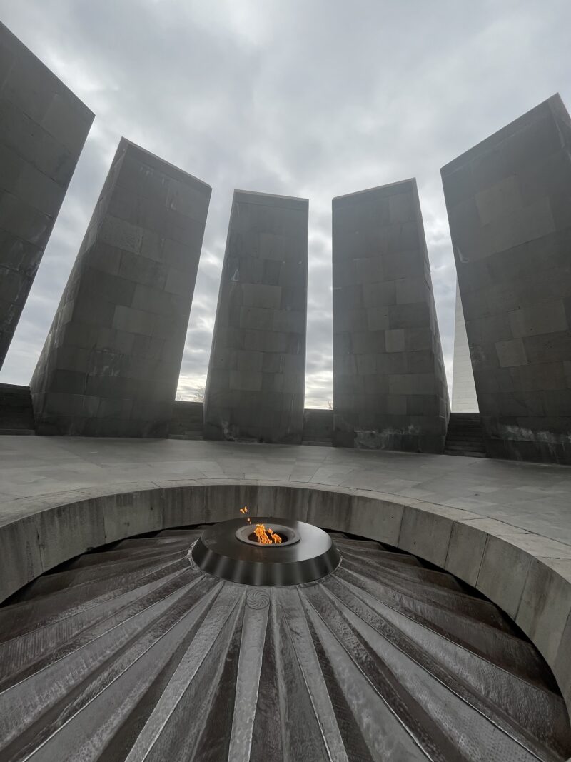 Eternal Flame at the Armenian Genocide Memorial – The Eternal Flame burns at the center of a circular stone structure with towering, leaning slabs, part of the Armenian Genocide Memorial in Yerevan.