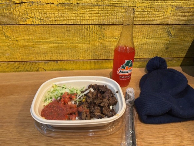 Bowl of mex foof and a red fruit punch soda