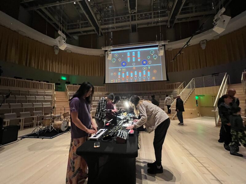 Four members of the MIT Laptop Ensemble set up audio and computer equipment during a soundcheck in the new Thomas Tull Concert Hall.