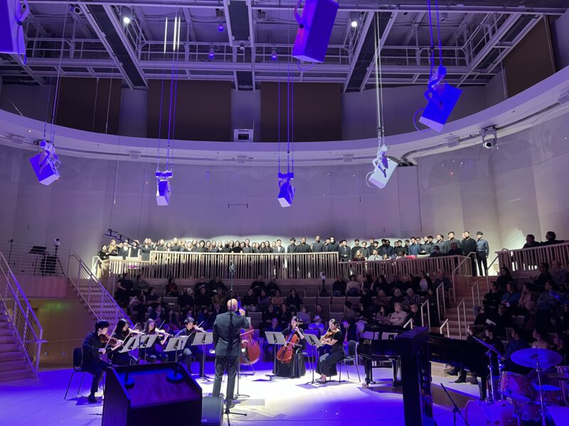 An ensemble of musician and vocalists performing in Tull Concert Hall.
