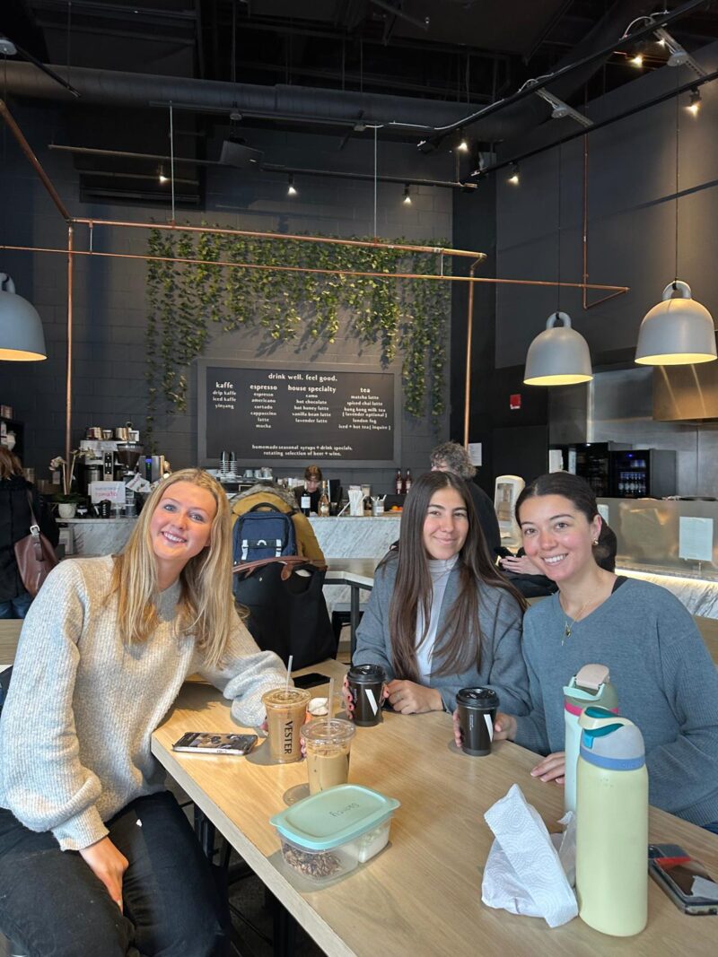 Three people smiling in a coffee shop.