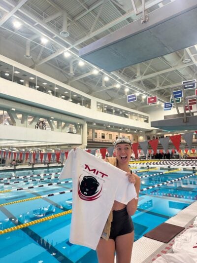 Person holding up tshirt in front of a pool.