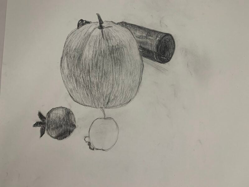 The drawing presents a clear glass bottle with a black nozzle, angled slightly to the right, positioned atop a round table. The bottle's contours are defined by soft, shaded lines, creating a sense of three-dimensionality. The round table is depicted from a slightly elevated perspective, contrasting against a gray background created with horizontal and vertical strokes of charcoal, producing a textured appearance. The overall composition centers the bottle, drawing focus to its form against the subdued backdrop.