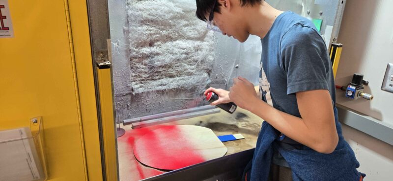 friend spraying ping pong paddle red