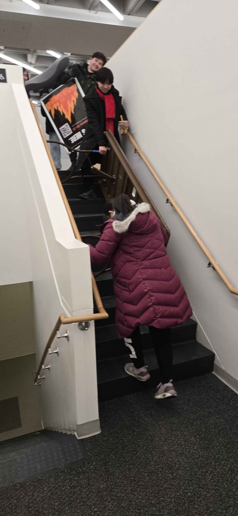 two people carrying table down stairs