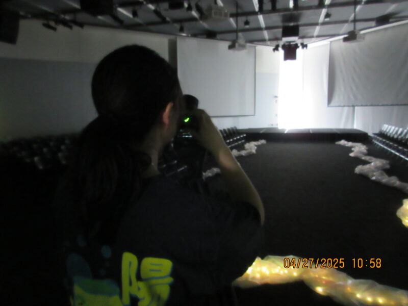 a girl setting up a camera pointing at an auditorium