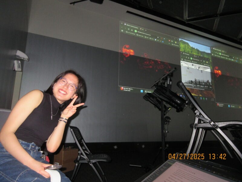 a girl grinning in front of a projected screen