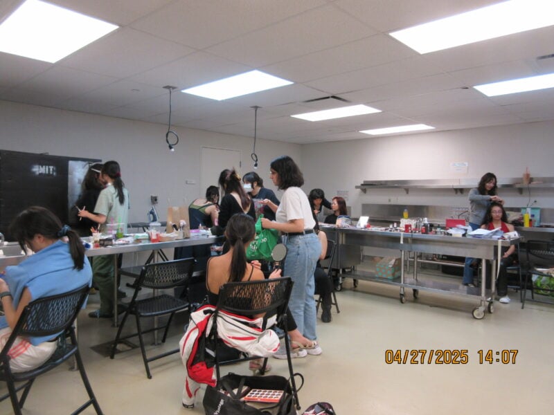 a picture of many people in a room with makeup and hair products