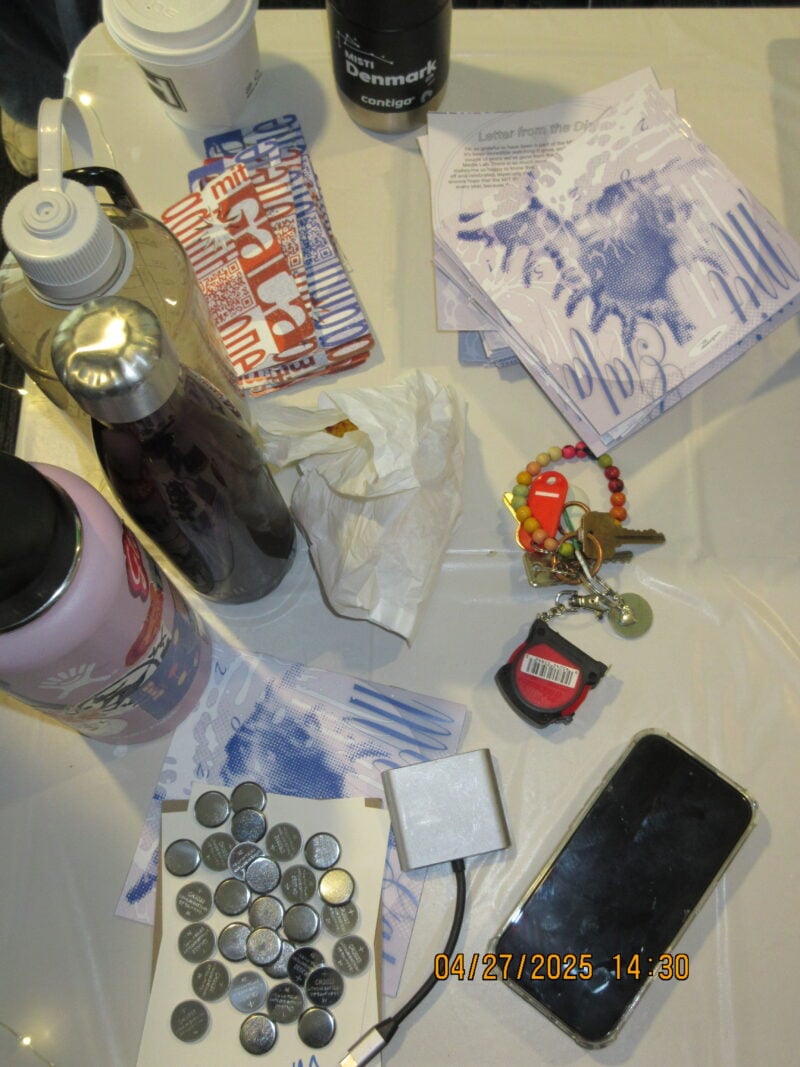 a top down view of a table with several water bottles and printed paper materials on it