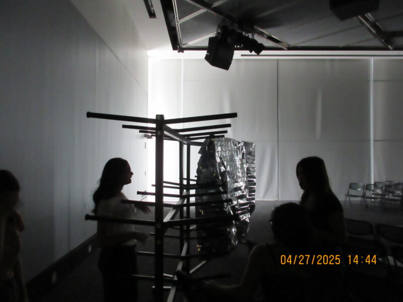 a bunch of chair racks in the dark with people, and mylar pinned to the sides