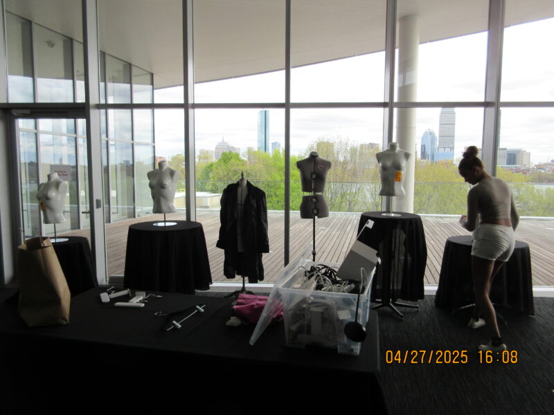 a girl setting up a bunch of mannequins on tables