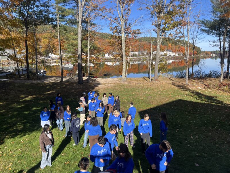 A group of people in a backyard, all wearing matching blue sweatshirts.