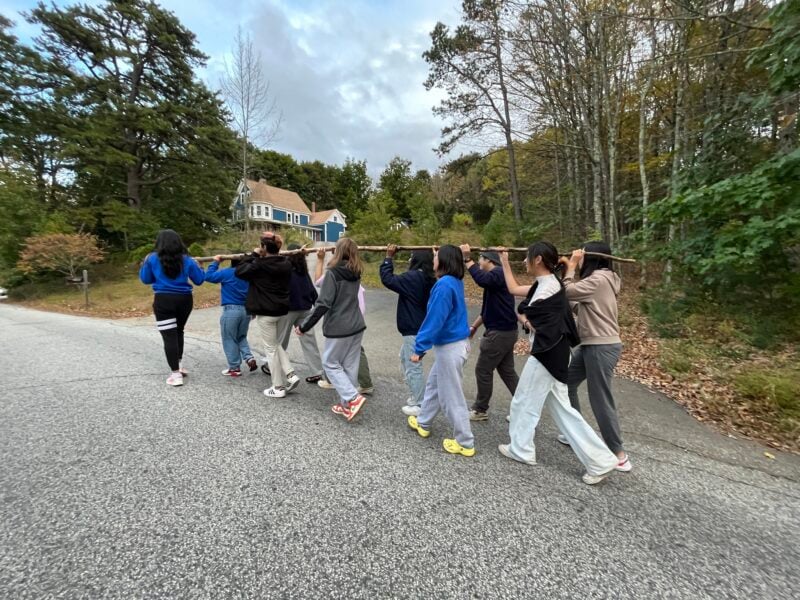 a group of people carrying a large stick