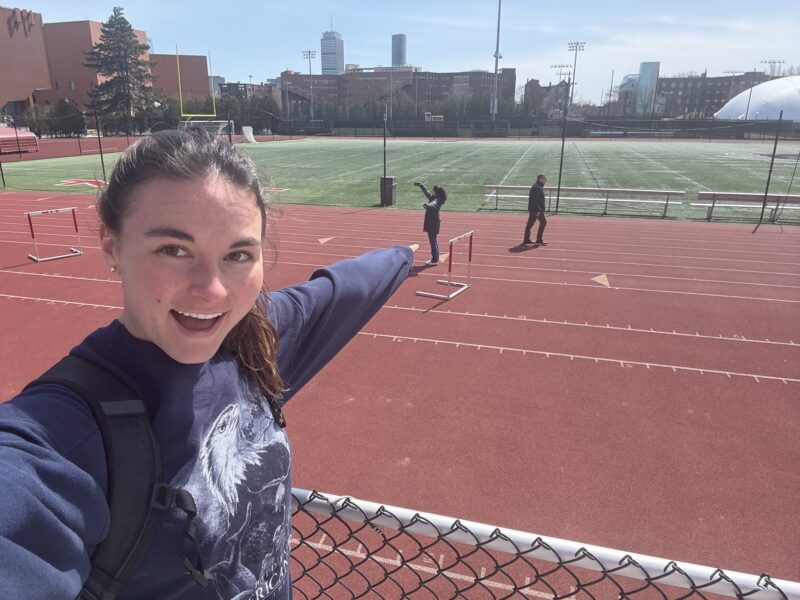 Selfie with a girl pointing at another person taking a selfie on a track.