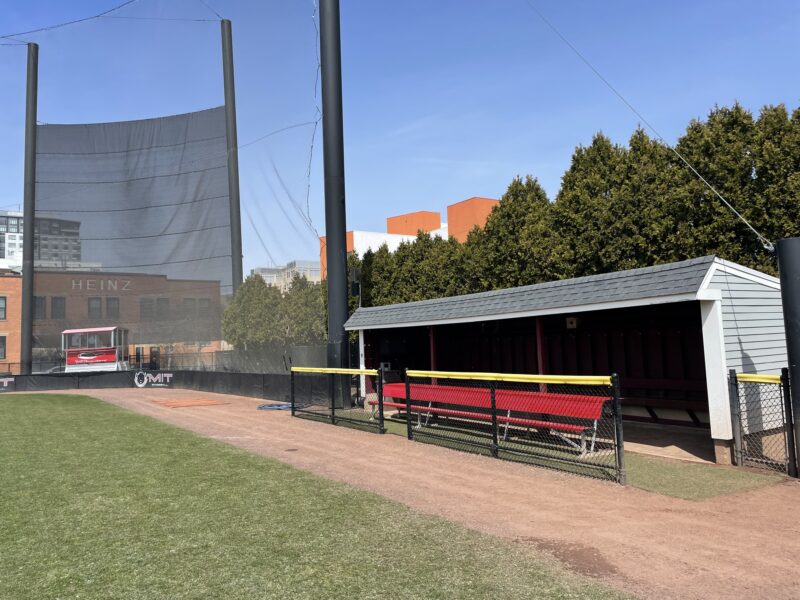 Baseball team dugout with red bench.