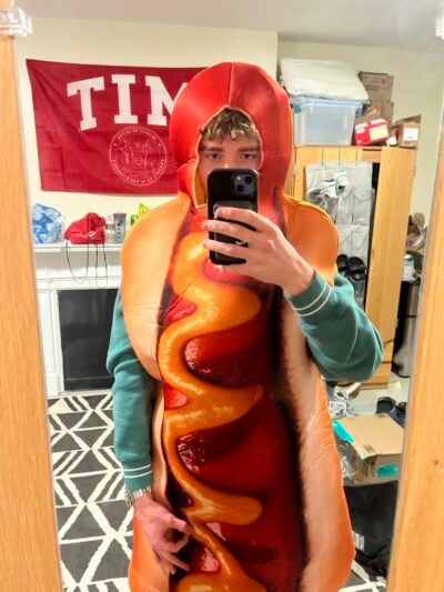 A selfie of a blonde boy in a hot dog costume