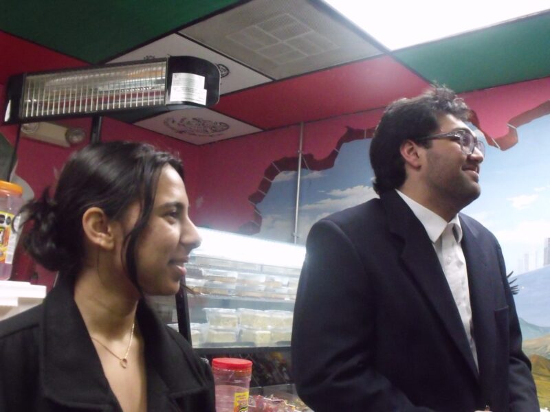 A boy and a girl smile and laugh in what appears to be a Mexican restauraunt.